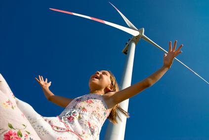 child playing with the wind near a wind turbine 
